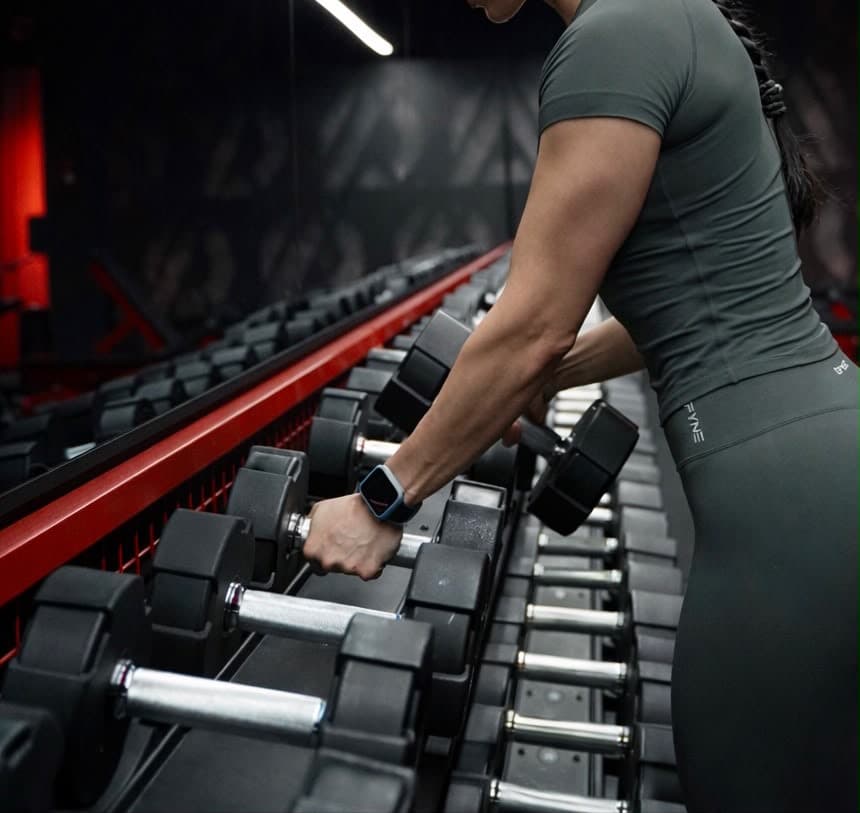 Coach Sportive Ova préparant une séance de musculation avec haltères
